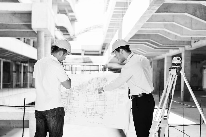 Engineers bekijken bouwtekening op locatie